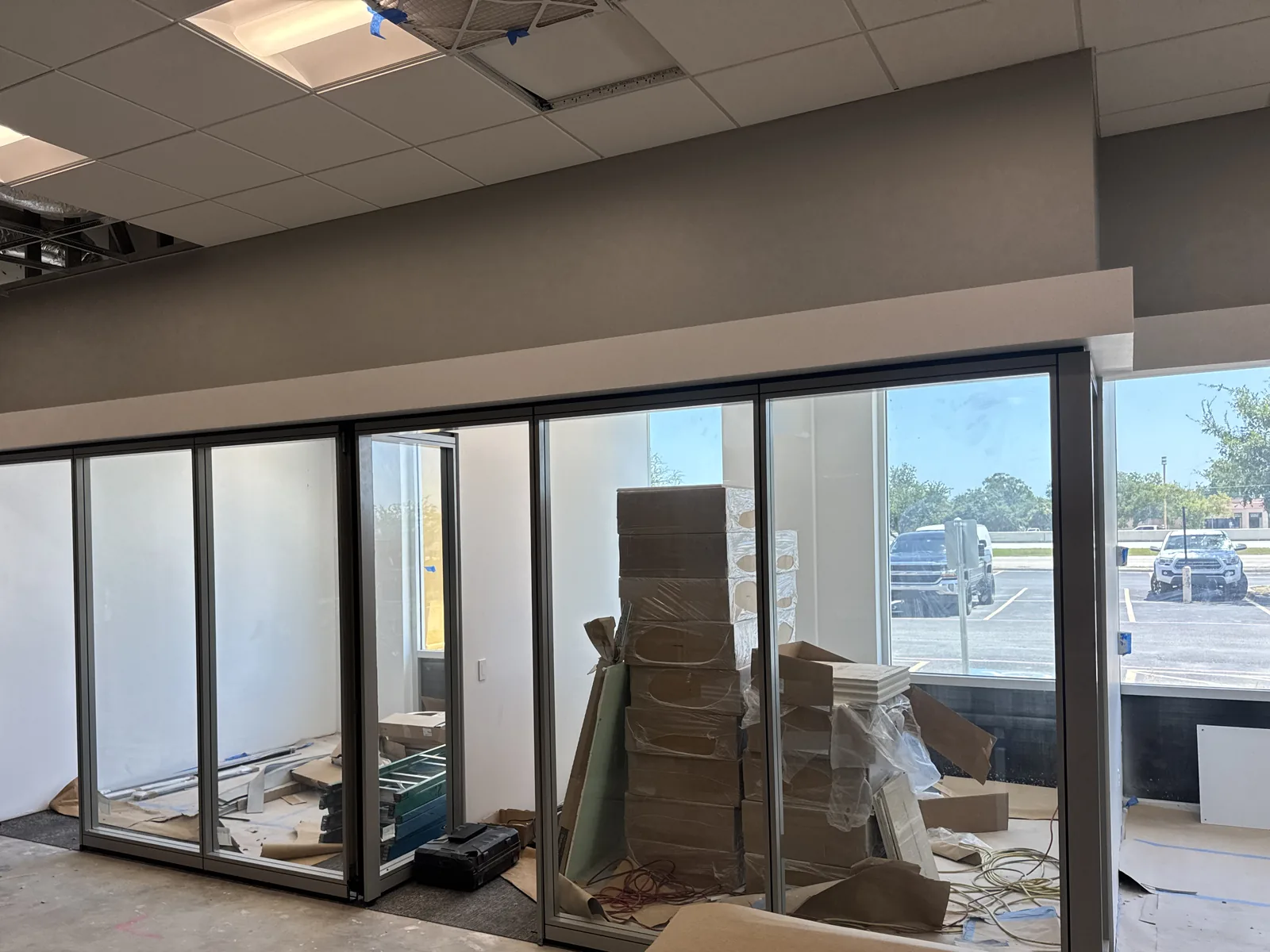 Row of glass-front offices along the storefront windows with boxes and materials inside.